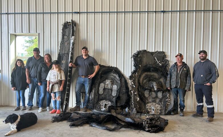 A few people standing with pieces of space junk 