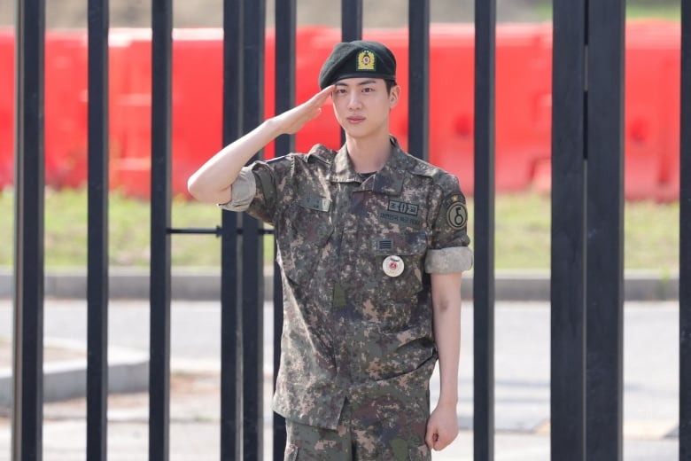 Jin, of the K-pop band BTS, poses for photographs in Yeoncheon, South Korea, after being discharged from the military.