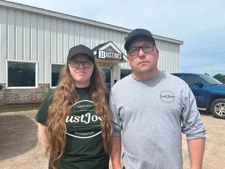 A woman and a man stand in front of Just Joes. 