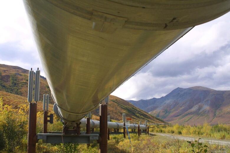 The view from under a large pipeline in a mountainous area.