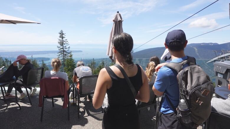 People sit on a patio on top of Grouse Mountain. 