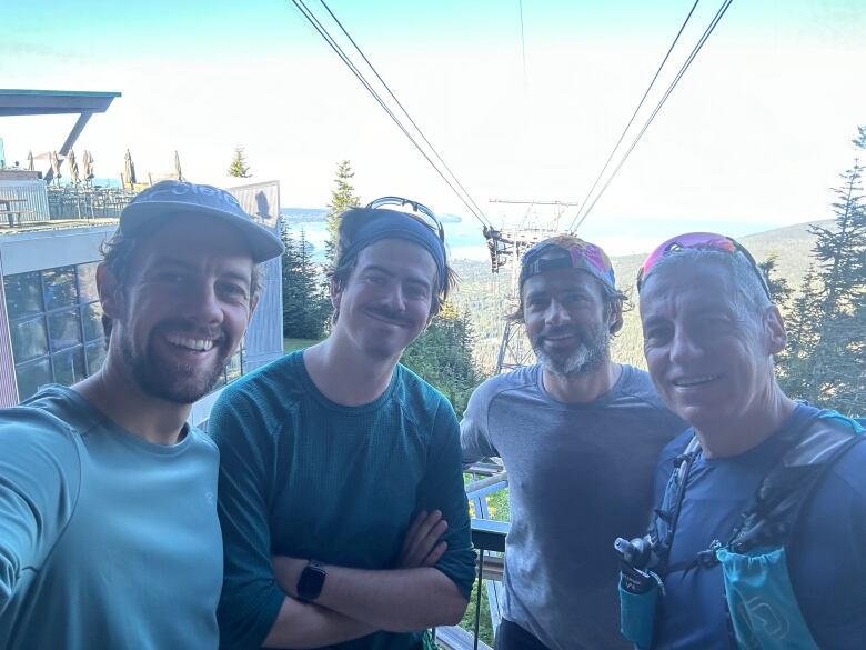 Four men in front of a mountain view.