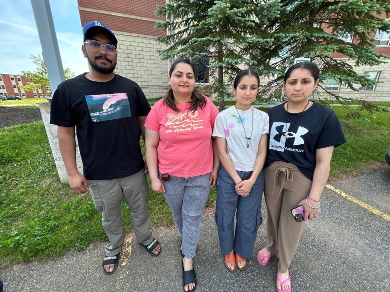 One man and three women standing in front of a hotel.