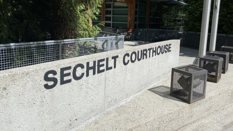 Outside of the Sechelt Courthouse, with the words written in bold text.