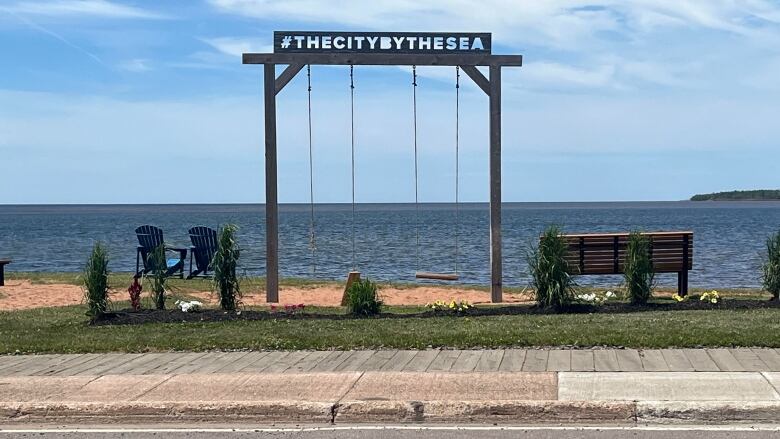 A swingset looks out on to the water.