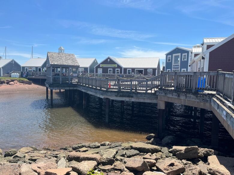 A boardwalk over water with small buildings.