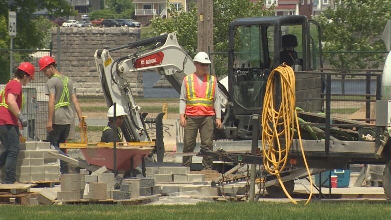 Construction workers, materials and construction machines at a construction site.