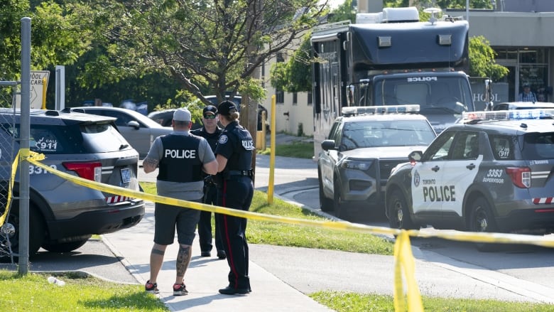 Toronto police officers investigate after three adults died in the lobby of an office space in Toronto, Monday, June 17, 2024. Police responded to reports of gunshots in an area near a school and a daycare. THE CANADIAN PRESS/Arlyn McAdorey