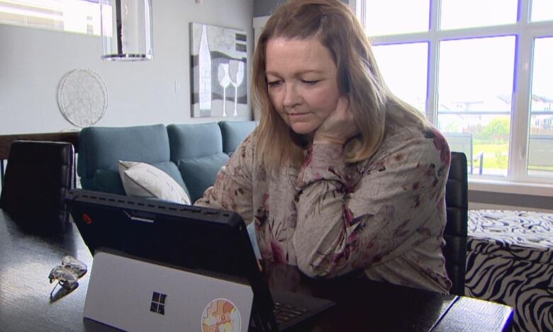 Jana Fatovic sits behind a laptop in her livingroom. 