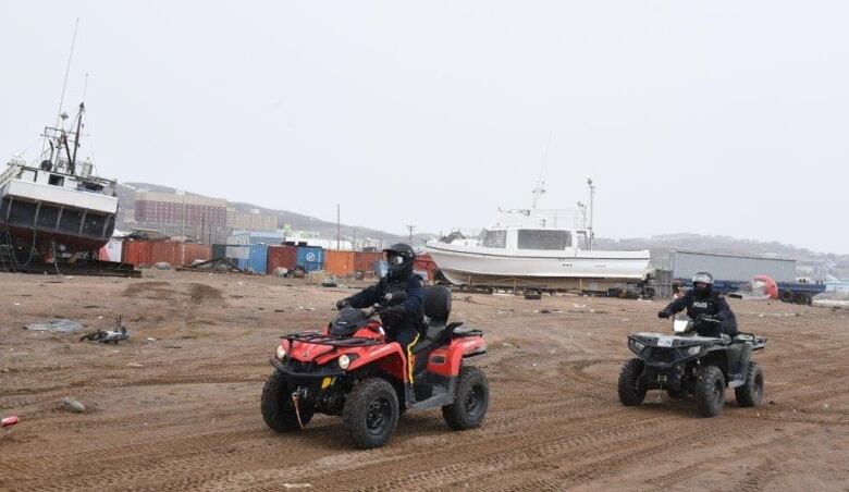 Iqaluit RCMP officers riding ATVs.