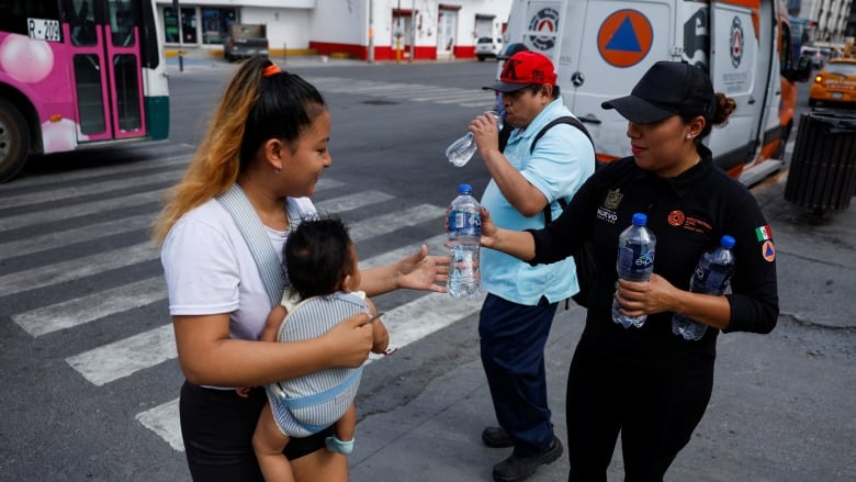 Civil Protection members hand out bottles of cold water during a heatwave in Monterrey, Mexico in May.