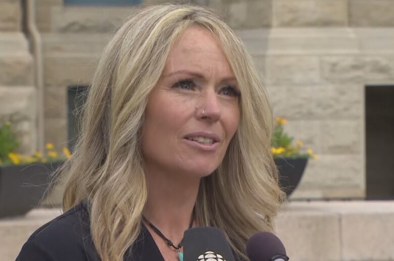 A woman answers questions from a reporter.