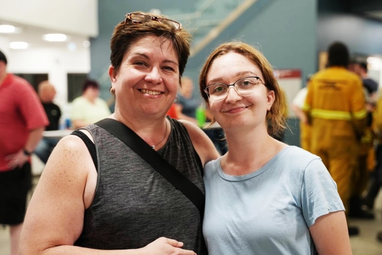 Woman and daughter standing side by side