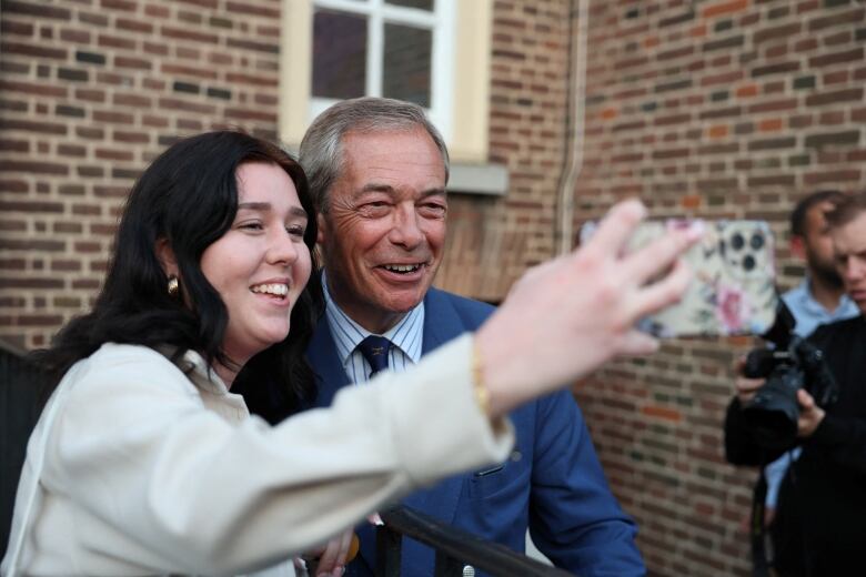 Britain's Reform UK Party Leader Nigel Farage takes a selfie with a supporter following a campaign event in Clacton-on-Sea, Britain, June 18, 2024. 