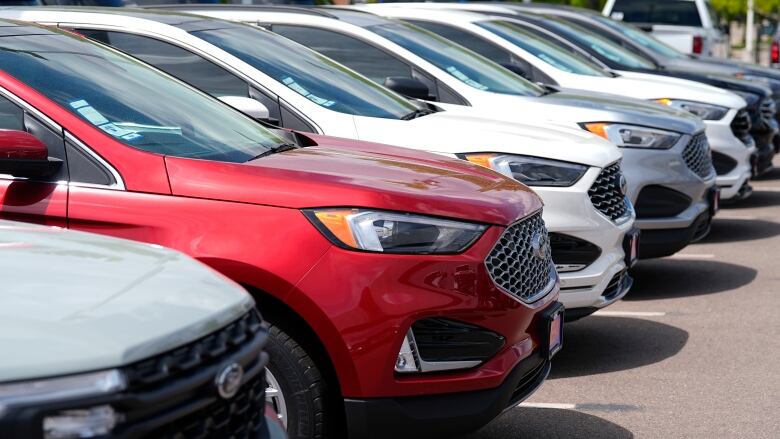 A row of cars at a dealership.