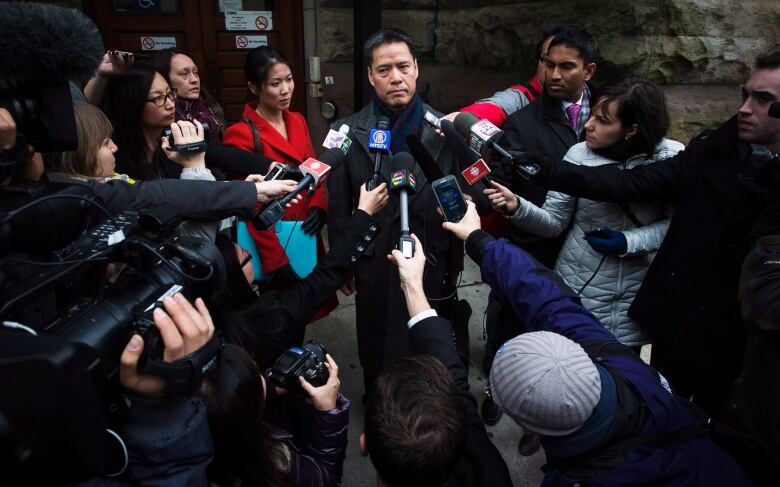 Man surrounded by microphones