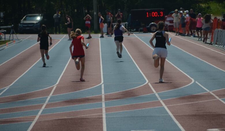 Four runners head down the track away from the camera