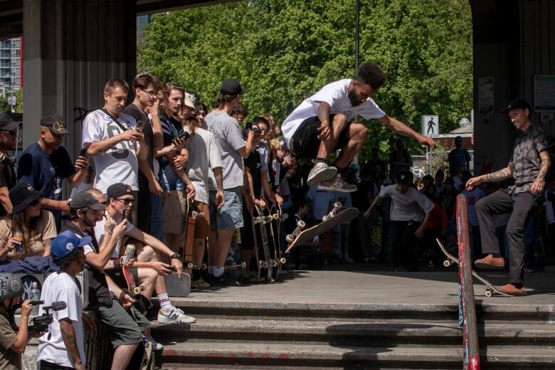 A skateboarder grabs some air using stairs.