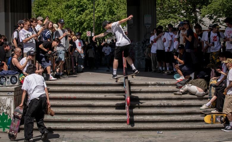 A skateboarder rides down a railing.