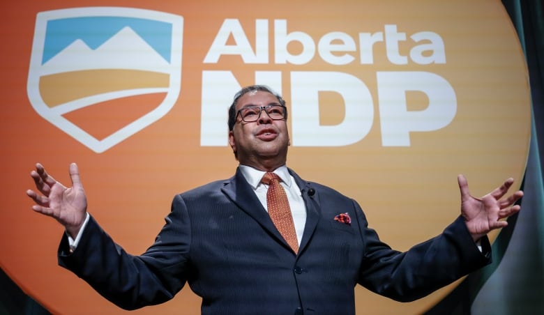 Nenshi holds his arms outwards.