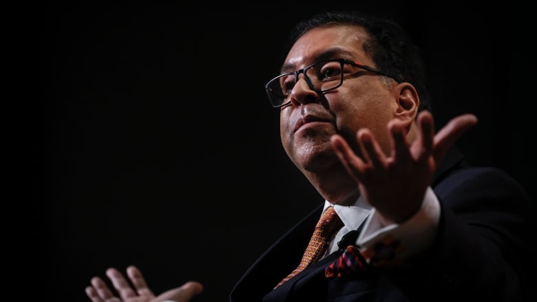 With a black background, Nenshi looks out to a crowd