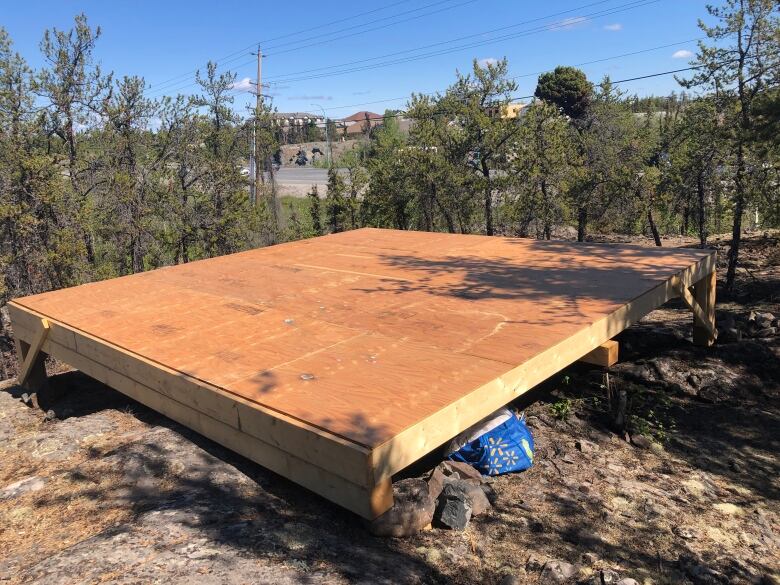 Wooden platform in pretty, high-up, treed place.