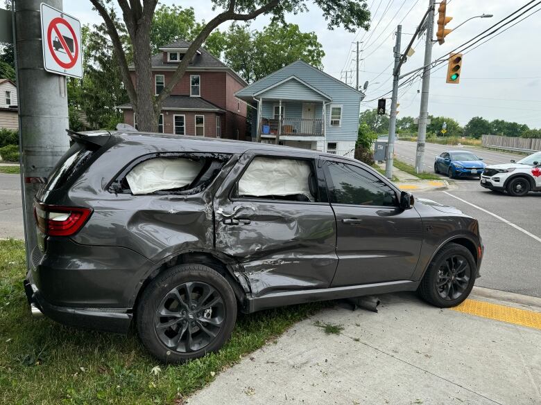 Crumpled SUV by utility pole.