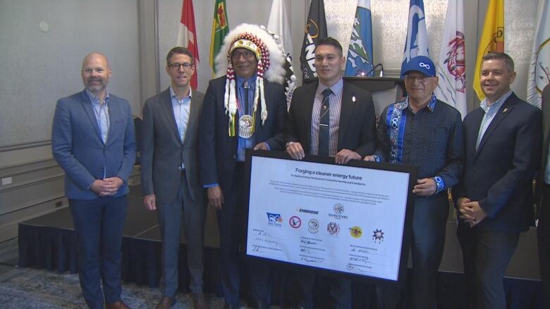 Government ministers, representatives from Enbridge and Indigenous leaders pose for a photo at a press conference on Monday.