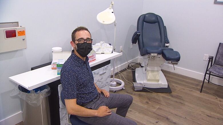 Man with health mask sitting in podiatry clinic.