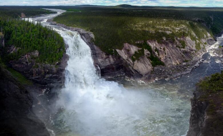 A waterfall with lots of water spilling down the side of the mountain.