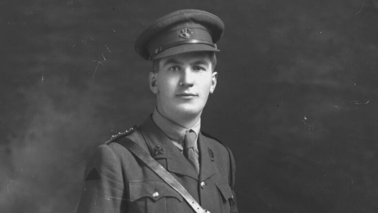 A black and white photo of a man in a military uniform. 