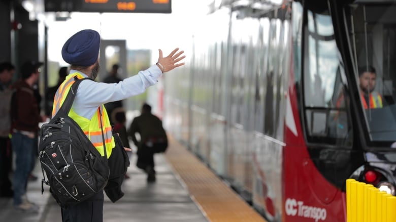 An LRT operator waves at the driver of incoming train.