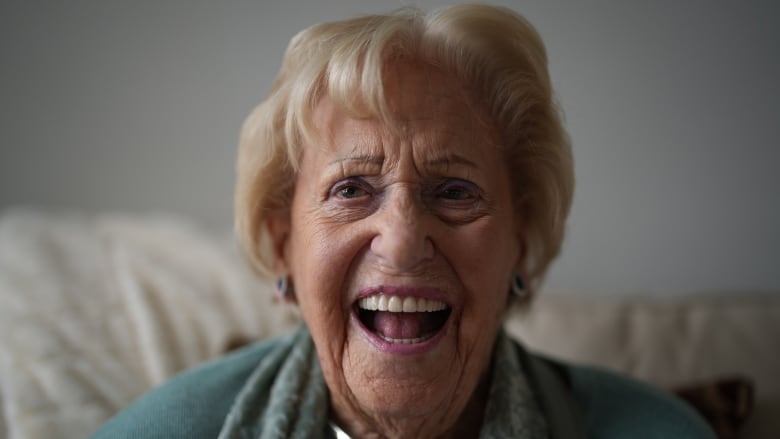 Vi Roden, 101, at her West Vancouver home. She is an older white woman who is smiling widely.