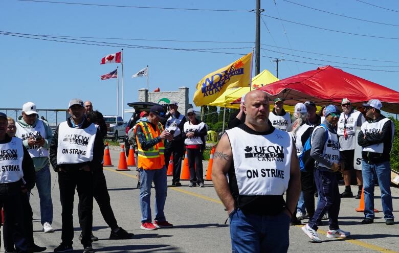 Photo of a man standing in front a blockade set up by the union turning away any vehicle trying to enter the Cargill beef slaughterhouse in Guelph