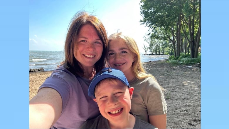 A woman and her two children on a beach.