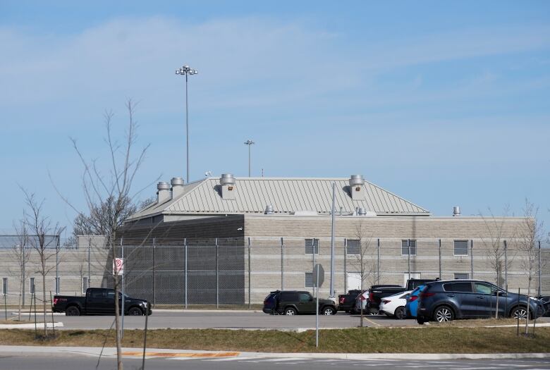 A jail is seen behind a tall fence.