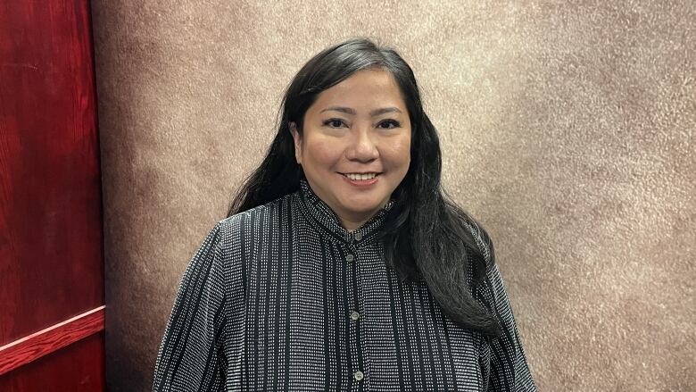 A black-haired woman smiles at the camera.