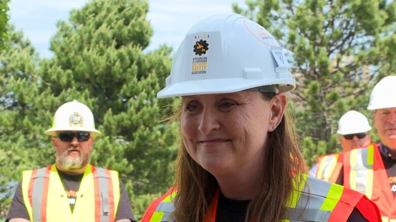 A woman in a white construction helmet.