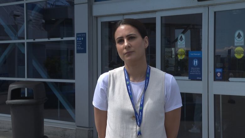 A communications official outside a ferry terminal talking with press. 