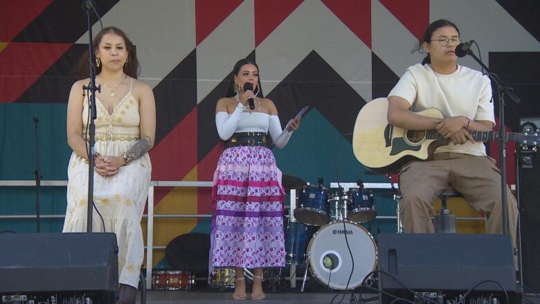 Three people on a stage.