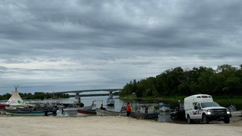 Several boats line the shore of a lake.