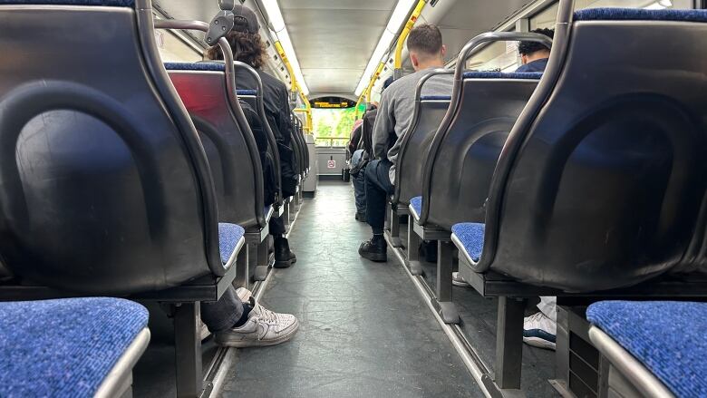 The top level of a double-decker OC Transpo bus at the start of summer. It's neither full nor empty.