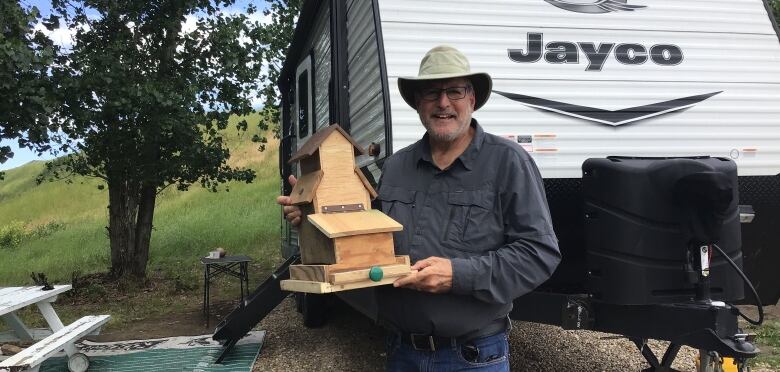 Ivan Cohen with grain elevator shaped bird feeder.