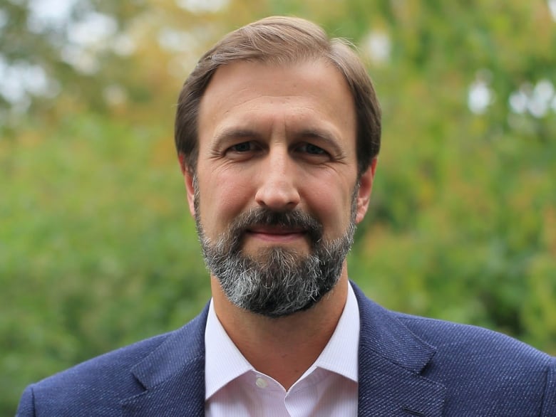 Man wearing navy blue blazer outside.