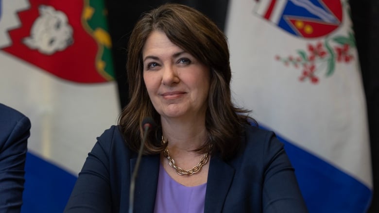 A woman with brown hair wearing a blazer.