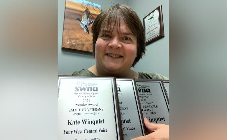 Kate Winquist holds awards from the Saskatchewan Weekly Newspapers Association.