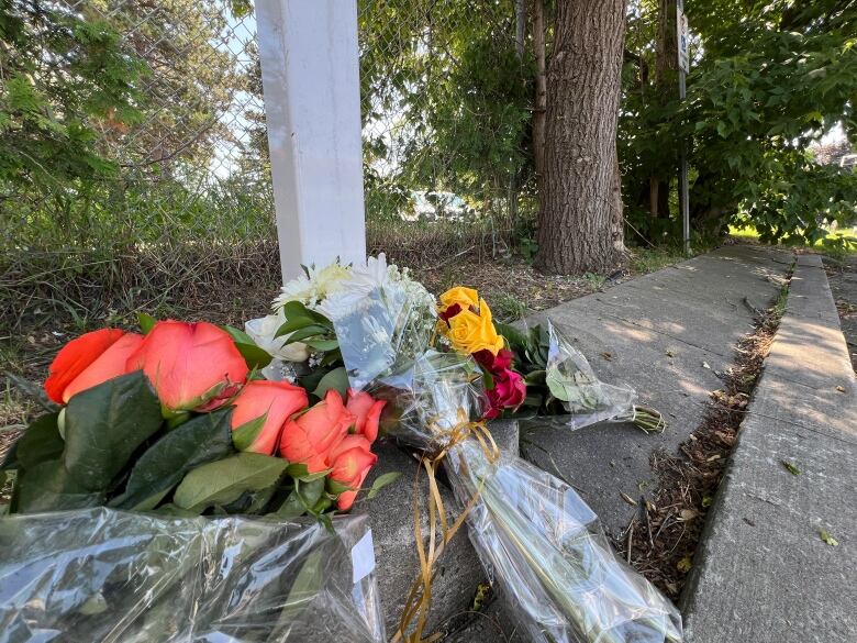 Photograph showing bouquets of flowers resting on a curb