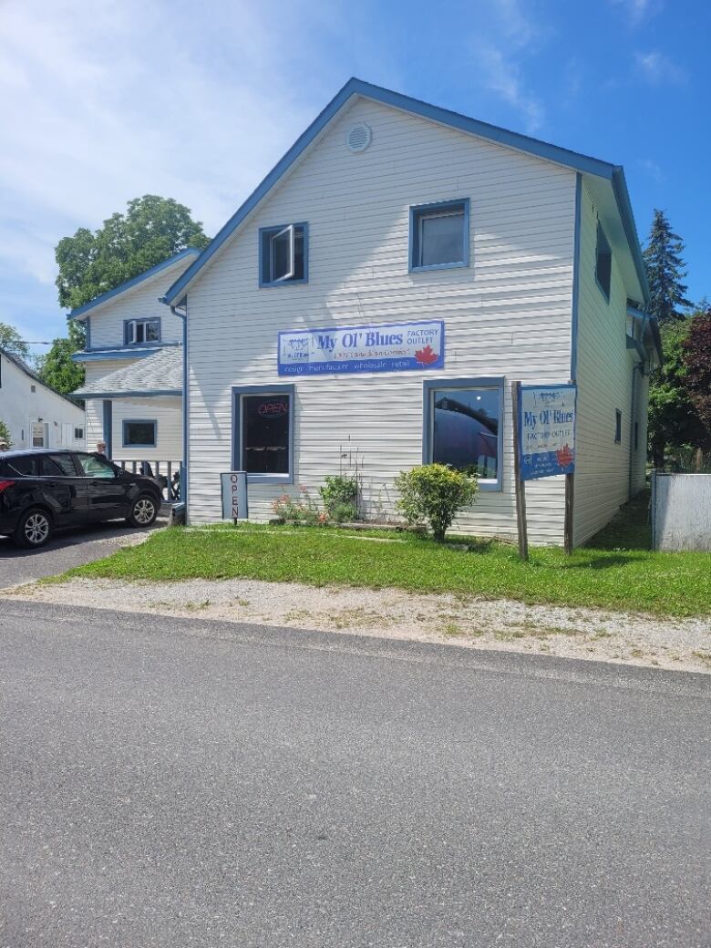 A white paneled building with blue rims on a bright summer day.