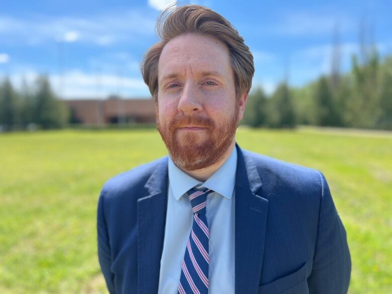 A portrait of a man with red hair and a beard in a suit. 