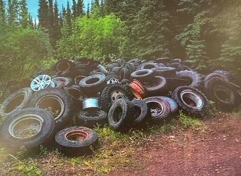 A large pile of tires in the outdoors.